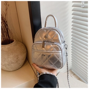 Close-up of silver mini square bag featuring quilted diamond pattern and chain strap
