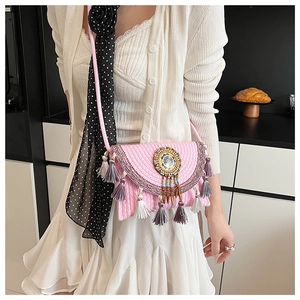 Detail of pink bohemian knitted crossbody bag with colorful beadwork and fringe tassels