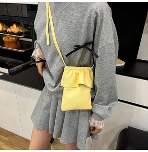 Détail du sac seau jaune avec bordure à volants et texture de cuir synthétique grainé