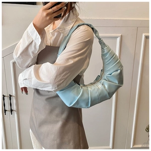 Close-up of light blue pleated croissant shoulder bag with soft PU leather texture