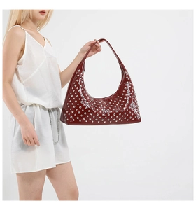 Detail view of burgundy glossy leather hobo bag with silver metallic stud decorations