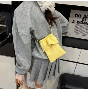 Vue détaillée du mini sac bandoulière jaune en cuir grainé avec rabat à bords plissés