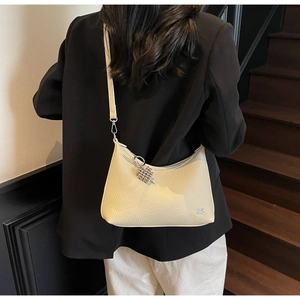 Detail view of cream dumpling tote bag with lychee texture and silver metal buckle charm