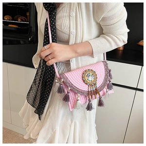 Close-up of pink boho woven crossbody bag with colorful beadwork and purple fringe details