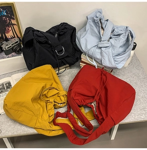 Vue détaillée de grands sacs à bandoulière à cordon en quatre couleurs avec plis
