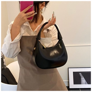 Dettaglio della borsa hobo in pelle verniciata nera con finiture dorate e logo