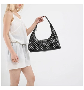 Close-up of black glossy hobo bag with silver metallic studs and sleek zipper detail