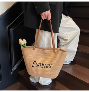 Détail du sac cabas en paille tressée avec broderie Summer et anses en cuir marron