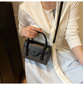 Détail du petit sac carré à carreaux avec logo PAN TOR et poignée à billes unique
