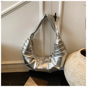 Close-up of silver crescent hobo bag featuring premium pleated metallic texture and sheen