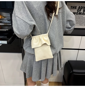 Détail du sac à téléphone crème avec cordon de serrage et texture en cuir grainé