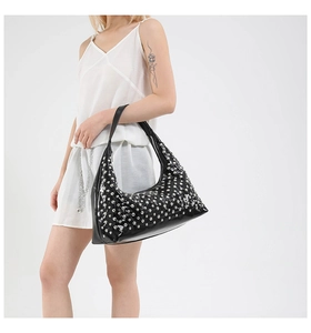 Detail of a black hobo bag with silver metallic studs and high-gloss leather finish