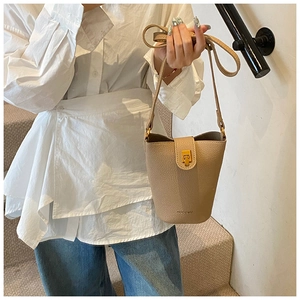 Detail of apricot bucket bag with lychee texture and gold metal twist lock closure