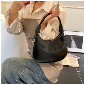 Dettaglio della borsa hobo in pelle nera con manico largo, zip e fibbia in metallo oro