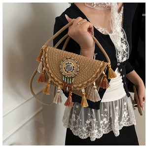 Detail of bohemian woven shoulder bag with ethnic bead embroidery and colorful tassels