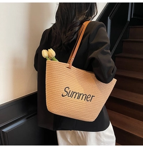 Détail du sac de plage tressé avec broderie Summer et anses en cuir marron