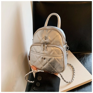 Detail of silver metallic quilted mini bag with floral ornament and chain strap