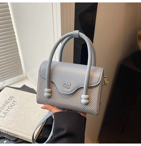 Gros plan du sac à main bleu clair montrant le logo PAN TOR et la poignée à perles unique