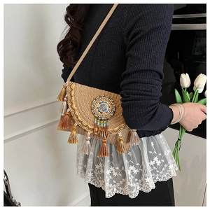 Detail of ethnic straw bag featuring colorful bead embroidery and sequined fringe tassels
