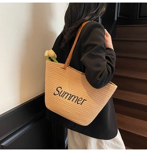 Sac fourre-tout en paille avec broderie Summer et anses en cuir sur un mannequin