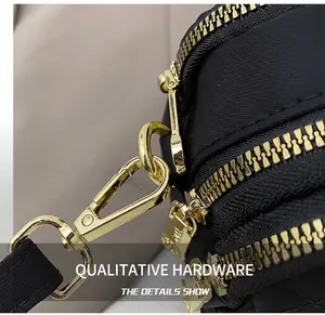 Close-up of golden metal hook and premium zipper system on black nylon bag