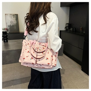 Détails du sac à bandoulière rose à motif cerises avec plusieurs poches zippées