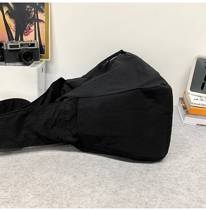 Détail du sac bandoulière minimaliste noir à cordon en tissu de nylon froissé
