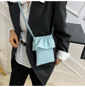 Détail du sac seau bleu clair avec texture grainée et bordures volantées élégantes