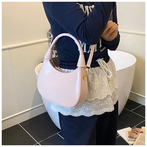 Close-up of pink crescent underarm bag in soft PU leather with metal strap hooks