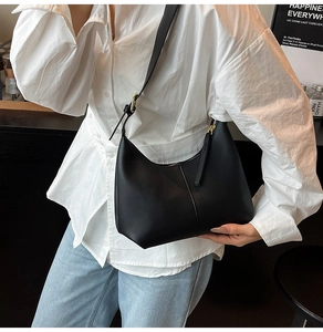 Chic black matte leather hobo bag with vertical stitching and adjustable shoulder strap