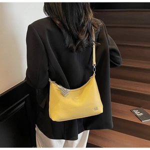 Detailed view of yellow lychee grain leather hobo bag with silver beaded charm detail