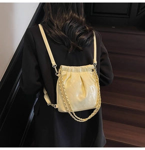 Detailed back view of a beige quilted leather drawstring backpack with gold chain straps