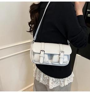 Detailed view of grey crossbody bag featuring double flap pockets and silver metal buckles