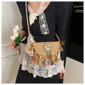 Detail of bohemian woven bag with colorful tassels, ethnic beads and gold embroidery