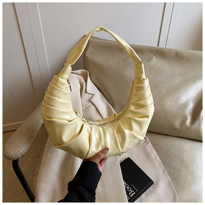 Detailed view of the light yellow pleated hobo bag with high-quality glossy texture