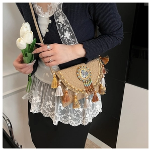 Close-up of bohemian straw bag featuring colorful tassels and ethnic beaded disc detail