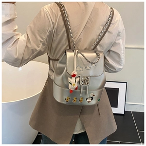 Detail eines silbernen Rucksacks mit Entenstickerei und Rosen-Metallverschluss