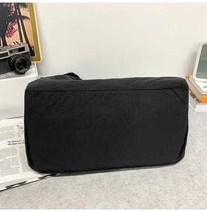 Gros plan du sac à bandoulière noir avec cordon de serrage montrant le tissu en nylon texturé