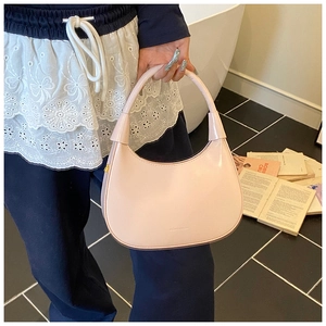Dettaglio della borsa hobo rosa con trama in pelle liscia ed elegante manico curvo