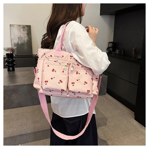 Sac fourre-tout rose en toile avec imprimé cerises, poches zippées et bandoulière réglable