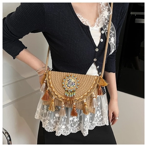 Close-up of bohemian straw bag with fringe tassels, colorful beadwork and lace trim