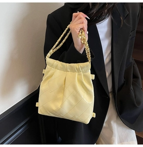Quilted cream chain bag on shoulder showing elegant style and compact size on model