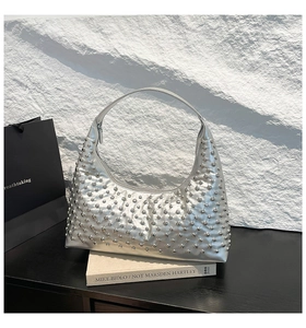 Close-up of silver hobo bag with metallic finish and decorative silver round rivets