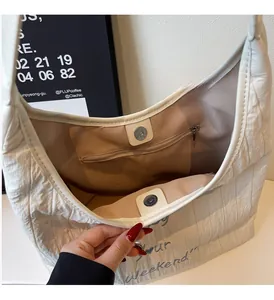 Detail view showing internal zipper pocket and magnetic closure of white canvas tote bag