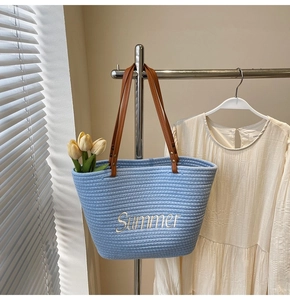 Détail du sac cabas tissé bleu clair avec broderie Summer blanche et anses en cuir