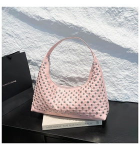 Macro detail of pink patent leather hobo bag with silver metallic punk rivets decoration