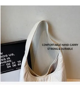 Detail showing the white pleated fabric texture and sturdy shoulder strap of the tote bag