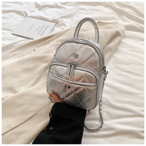 Detail of silver metallic quilted mini bag with double zippers and chain strap