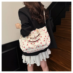 Détail du sac cabas blanc à imprimé cerise avec doubles poignées et bandoulière