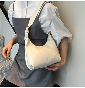 Detailed view of cream hobo bag with adjustable strap and minimalist stitching on PU leather